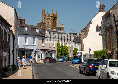 Cerne Abbas, England, UK - 29. Juni 2019: Fußgänger vorbei an traditionellen Cottages in der Long Street in der malerischen Ortschaft Cerne Abbas in Dorse Stockfoto