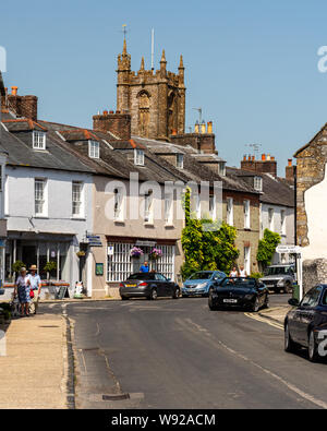 Cerne Abbas, England, UK - 29. Juni 2019: Fußgänger vorbei an traditionellen Cottages in der Long Street in der malerischen Ortschaft Cerne Abbas in Dorse Stockfoto