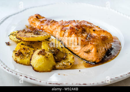 Gegrillter Lachs mit Honig Glaze, Butter und gebackene Kartoffeln gebrannt. Bereit zu dienen Stockfoto