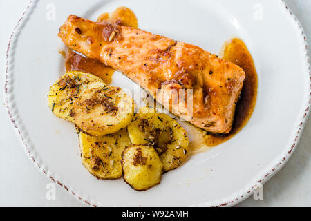 Gegrillter Lachs mit Honig Glaze, Butter und gebackene Kartoffeln gebrannt. Bereit zu dienen Stockfoto