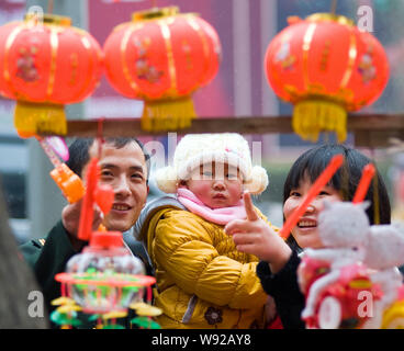 ---- Ein chinesisches Ehepaar und ihr einziges Kind shop für rote Laternen auf einem Markt in Yiyang City, Central China Provinz Henan, 4. Februar 2012. Chin Stockfoto