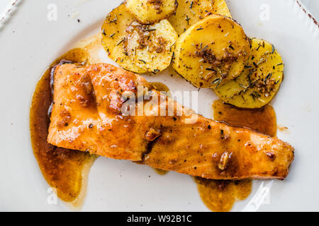 Gegrillter Lachs mit Honig Glaze, Butter und gebackene Kartoffeln gebrannt. Bereit zu dienen Stockfoto