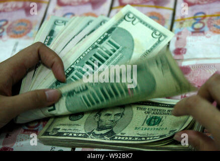 ---- Eine chinesische Angestellte zählt US Dollar auf Yuan bei einer Bank in der Stadt Huaibei, East China Provinz Anhui, 28. November 2012. Eine vernachlässigbare Anzahl Stockfoto