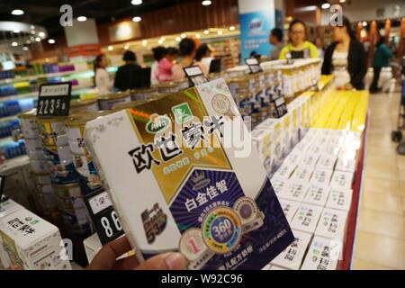 ---- Ein Kunde kauft einen Kasten von Mengniu Arla Milchpulver in einem Supermarkt in Xuchang, Zentrale China Provinz Henan, 5. Oktober 2013. China Mengniu Stockfoto