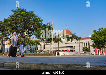 Mitglieder einer Singapurischen ethnischen Malaien Familie vorbei an der neuen Parlamentsgebäude in der Nähe von Boat Quay, Singapore Stockfoto