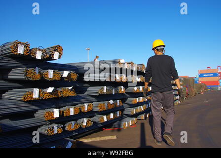 ---- Ein chinesischer Arbeiter untersucht einen Stapel vom Verstärken von Stahl Stäbe in einem Stahlwerk in Rizhao, die exportiert werden sollen, East China Provinz Shandong, 4 Octobe Stockfoto