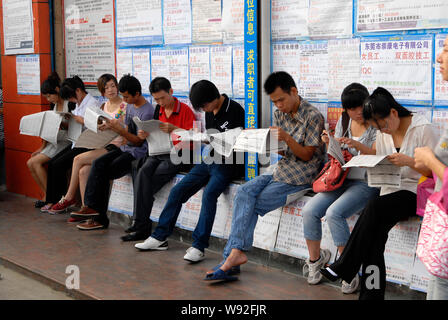 ------ Jungen chinesischen Arbeitsuchende lesen Einstellung Informationen in Zeitungen auf einem Arbeitsmarkt, in Dongguan City, South China Guangdong Provinz, 28 A Stockfoto