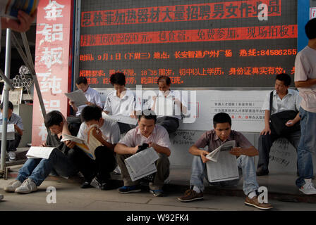 ---- Chinese Arbeitsuchende lesen Einstellung Informationen in Zeitungen auf einem Arbeitsmarkt, in Dongguan City, South China Guangdong Provinz, am 28. August 2001 Stockfoto