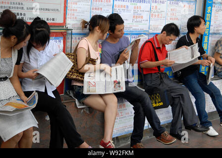 ---- Chinese Arbeitsuchende lesen Einstellung Informationen in Zeitungen auf einem Arbeitsmarkt, in Dongguan City, South China Guangdong Provinz, am 28. August 2001 Stockfoto