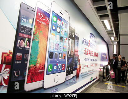 ---- Fußgänger vorbei eine Anzeige der Apple iPhone 5S und andere Smartphones mit Android von Google in Nanjing installiert Stockfoto