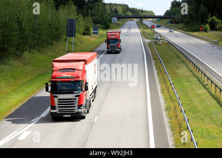 Salo, Finnland. Juli 19, 2019. Zwei rote Scania R450 Frode Laursen Auflieger Lkw fahren entlang der Autobahn auf finnische Nationalstraße 1, E 18, oben betrachten. Stockfoto