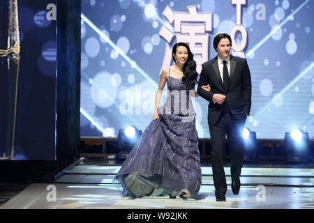 Kanadische Schauspieler und Regisseur Keanu Reeves, rechts, Hong Kong Sängerin und Schauspielerin Karen Mok gehen auf die Bühne, für die Beste Regie Award zu verkünden Stockfoto