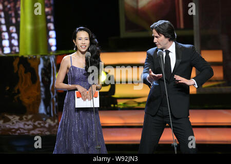 Kanadische Schauspieler und Regisseur Keanu Reeves, rechts, führt Tai Chi neben Hongkong Sängerin und Schauspielerin Karen Mok, wie sie für die Beste Regie aw verkünden Stockfoto