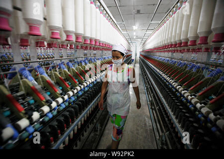 Ein weiblicher chinesischer Arbeiter an Maschinen zum Spinnen in einer Textilfabrik in Stadt Huaibei, East China Provinz Anhui, 1. Juli 2013. China manufacturi Stockfoto