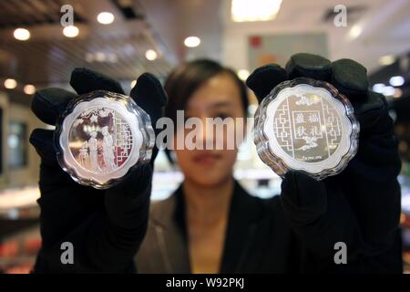 ---- Eine chinesische Angestellte zeigt Silber mooncakes an einem gold Shop in Zhoukou City, Central China Provinz Henan, 29. August 2013. China hat offic verboten Stockfoto