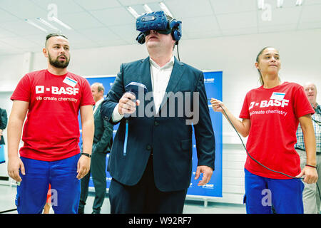 Ludwigshafen, Deutschland. 12 Aug, 2019. Hubertus Heil (SPD), Bundesminister für Arbeit und Soziales, ist Sie die Funktionalität von Virtual reality Brillen mit Praktikanten aus der Chemiekonzern BASF. Der Sekretär der Arbeit ist auf einer Sommerreise. Foto: Uwe Anspach/dpa/Alamy leben Nachrichten Stockfoto