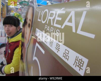 ---- Eine chinesische Angestellte an der Theke der LOreal Kosmetik und Hautpflege Produkte in einem Supermarkt in Nantong City steht, East China Jiangsu Provinz Stockfoto