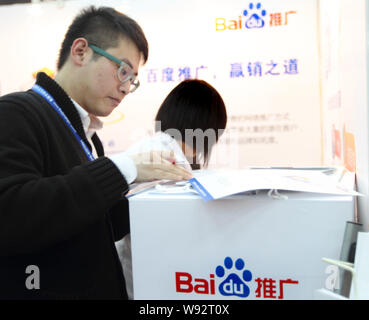 ---- Ein Mitarbeiter ist auf dem Stand von Baidu, der chinesischen Internet Search Engine gesehen, während einer Ausstellung in Peking, China, 21. November 2010. Bai Stockfoto