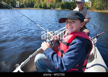 Junge Junge lächelt als er Rollen in einem Zander auf einem Minnesota See Stockfoto