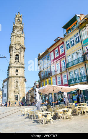 Porto, Portugal - 31. August 2018: Die berühmten Clerigos Kirche Igreja e Torre dos Clerigos in Portugiesisch. Traditionelle Häuser mit bunten Fassaden, Straße mit Geschäften und Restaurants. Sonnigen Tag. Stockfoto