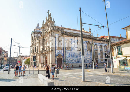 Porto, Portugal - 31. August 2018: Die Menschen auf der Straße von den berühmten Igreja do Carmo und angrenzenden Igreja dos Carmelitas. Traditionelle portugiesische Kacheln azulejos auf Kirche Fassade. Straße mit Menschen. Stockfoto