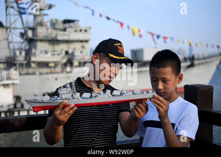 (190812) - NANCHANG, 12.08.2019 (Xinhua) - Yang Shuangfeng (L) hält ein Modell der DDG-163 Nanchang, eine decommisioned Zerstörer Schiff, als er das Schiff führt zu seinem Sohn in Nanchang, Osten Chinas Provinz Jiangxi, Aug 8, 2019. Nachdem es im September 2016 stillgelegt wurde, DDG-163 Nanchang, eine Art 051 geführte-missile Destroyer der Volksbefreiungsarmee (PLA) Marine, bleibt eine Touristenattraktion in Nanchang, der Stadt, nach dem es benannt wurde. Zum Navy veteran Yang Shuangfeng, der letzte Chefingenieur auf DDG-163 das Schiff bedeutet mehr wie ein Genosse als nur eine touristische Destination. Wenn DDG Stockfoto