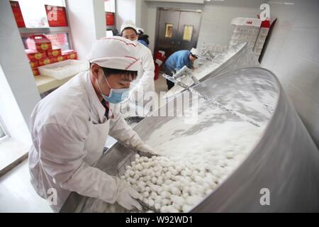 Chinesische Arbeiter machen Klebreis knödel, auch als Yuanxiao, Yuan Xiao oder Tang Yuan bekannt, in einem Geschäft vor der bevorstehenden Laternenfest, auch Stockfoto