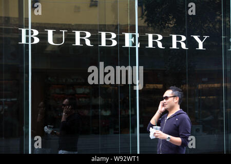 Ein Fußgänger geht hinter einem Burberry Store in Shanghai, China, 17. September 2012. Stockfoto