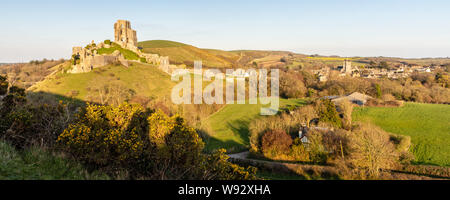 Abend Sonne scheint auf die verfallenen Mauern der mittelalterlichen Burg von Corfe Castle in in Dorset Purbeck Hills. Stockfoto