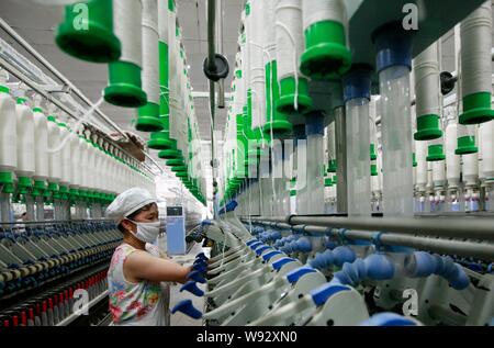 Ein weiblicher chinesischer Arbeiter übernimmt Produktion von Garn nach Südostasien in einer Textilfabrik in Stadt Huaibei, die exportiert werden sollen, East China Provinz Anhui, 15. Stockfoto