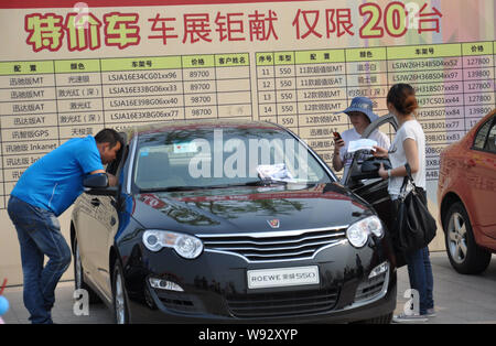 ---- Besucher Blick an einem Roewe 550 der SAIC Motor während eines Auto Show in Qingdao Stadt, East China Provinz Shandong, 5. Mai 2012. SAIC Motor Corp., Stockfoto