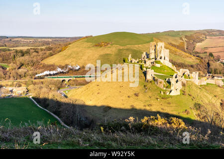 Corfe Castle, England, Großbritannien - März 27, 2019: ein dampfzug die Ruinen von Corfe Castle auf der Swanage Railway im in Dorset Purbeck Hills. Stockfoto