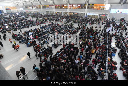 Eine Masse von chinesische Passagiere auf ihrem Weg zurück zum Frühlingsfest oder das Chinesische Neue Jahr Warteschlange an der Shenyang North Railway Sta zu prüfen. Stockfoto