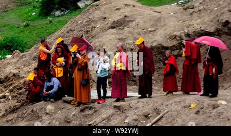 Lokale Lamas und Touristen Blick auf eine Herde von Geier nach einem Himmel Beerdigung in Sertar County, Ganzi tibetischen autonomen Präfektur, Southwest China Sichua Stockfoto