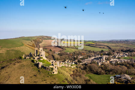 Corfe Castle, England, Großbritannien - 27 März, 2019: Vier Militärhubschrauber in Formation fliegen über Corfe Castle Dorf in Dorset. Stockfoto