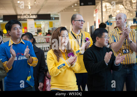 C Fredrik Johansson, Beck, zweite rechts, das neue Peking IKEA Store Manager, und andere Mitarbeiter willkommen Kunden am neuen IKEA Heimtextilien Stockfoto