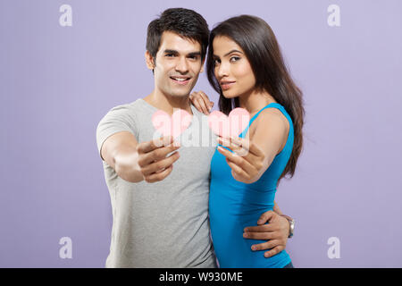 Junges Paar zeigt Herz Form Symbole Stockfoto