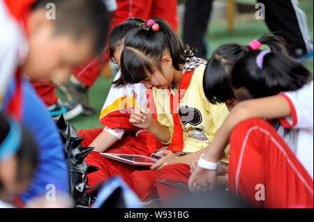 ------ Jungen Studenten spielen mobile Spiele auf ihren Apple iPad Tablet PCs während einer Pause an einer Grundschule in Lanzhou city, Northwest China Gansu pro Stockfoto