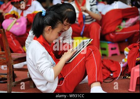 ------ Jungen Studenten spielen ein Spiel auf einem Apple iPad Tablet PC während einer Pause an einer Grundschule in Lanzhou city, Northwest China Gansu provin Stockfoto