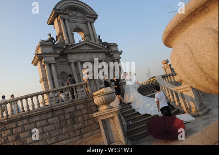 Junge chinesische Paare posieren für Fotos Hochzeit vor einem Pariser Stil der Architektur an Tianducheng, eine kleine chinesische Gemeinschaft Paris replizieren, ich Stockfoto