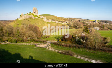 Abend Sonne scheint auf die verfallenen Mauern der mittelalterlichen Burg von Corfe Castle in in Dorset Purbeck Hills. Stockfoto