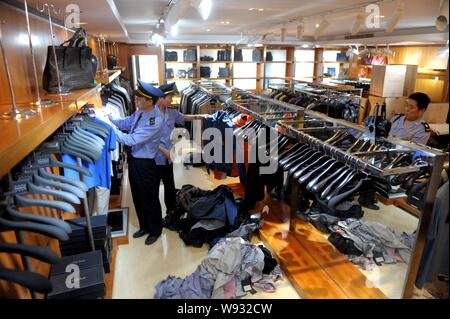 Chinesische Polizeibeamte fake Luxury Brand waren in einem Shop in Peking, China konfiszieren, 13. Mai 2013. Peking Polizei und Strafverfolgung aus Stockfoto