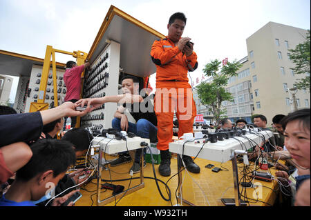 Arbeitnehmer können lokale Bewohner ihre Mobiltelefone, Batterien an einem mobile Ladestation zum Aufladen nach dem 7,0-Erdbeben in Lushan c Stockfoto