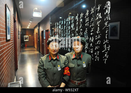 Die Kellnerinnen im Roten Garde Uniformen stehen vor der calligraph von Mao Zedong am Maos Restaurant in Stadt Bozhou, East China Provinz Anhui, 8 M Stockfoto