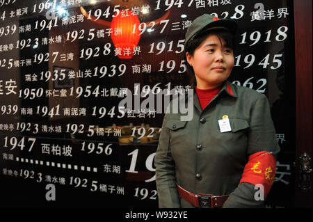 Eine Kellnerin in roten Garde Uniformen steht vor eine Chronik von Mao Zedongs Veranstaltungen an der Maos Restaurant in Stadt Bozhou, East China Anhui provinc Stockfoto