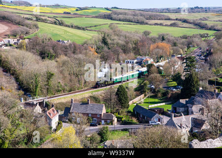 Corfe Castle, England, UK - 27. März 2019: eine Dampflok zieht weg von Corfe Castle Station auf der Swanage Railway Heritage Line in in Dorset Purbec Stockfoto