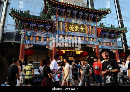 ---- Fußgänger vorbei ein Zweig der Quanjude auf Wangfujing Street in Peking, China, 28. Juli 2013. Private-equity-Firmen sind auf der Suche zu erfüllen Stockfoto