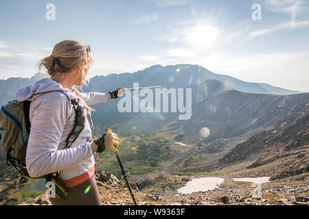 Eine junge Frau Trail Runner weist auf ihrer Spur in der Ferne Stockfoto