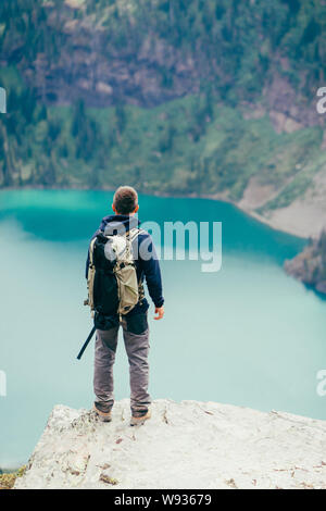 Wanderer steht auf einer Klippe am See in GlacierNP, Montana suchen Stockfoto