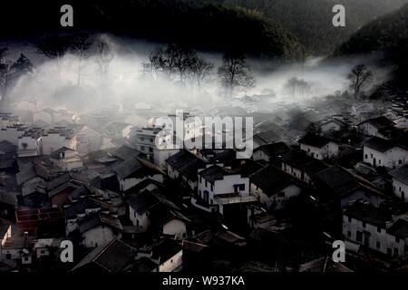 Bezaubernde Nebel teilweise deckt Häuser im Dorf, Shicheng Wuyuan County, Stadt Shangrao, East China Provinz Jiangxi, 17. Januar 2013. Stockfoto